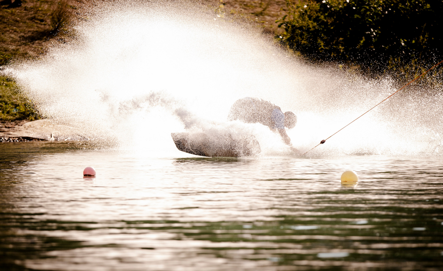 Wakeboarder fährt durch eine große Wasserfontäne im Wasserskipark Zossen